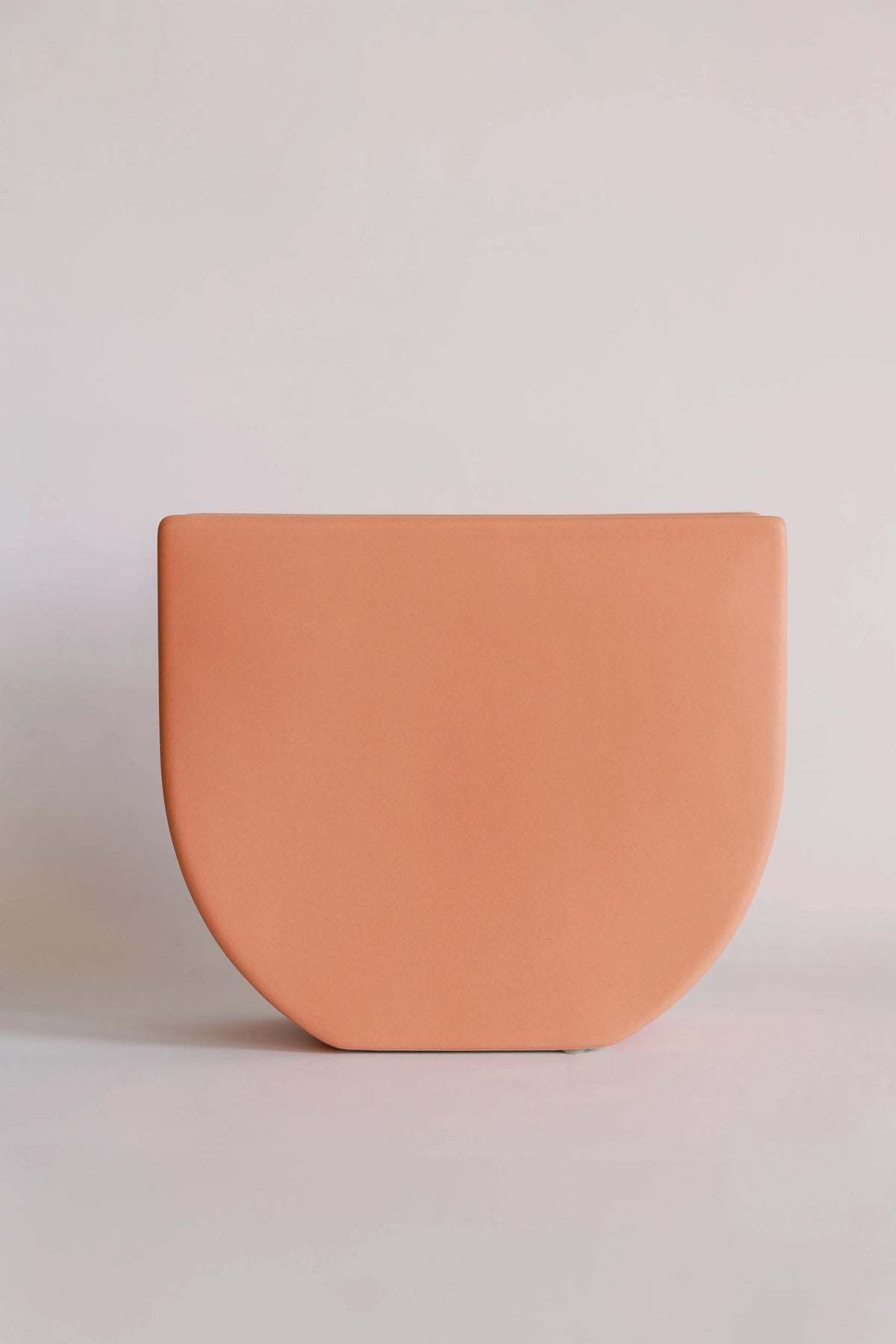 Sunrise ceramic vase in matte peach, rounded base and flat top edge against soft pink backdrop