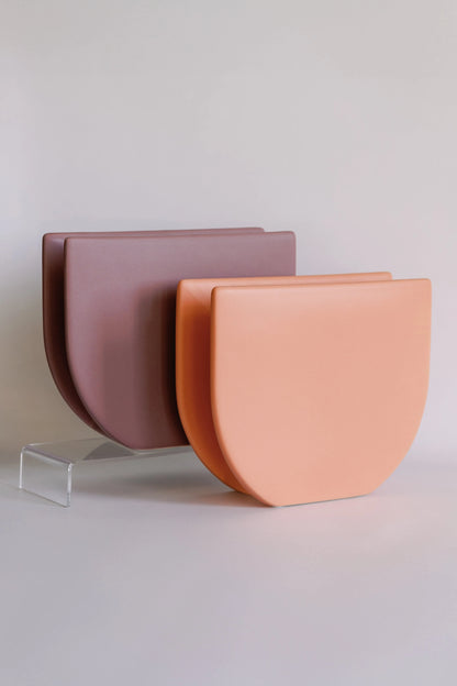 Two Sunrise ceramic vases styled together, mauve pink and peach pairs leaning on an acrylic riser