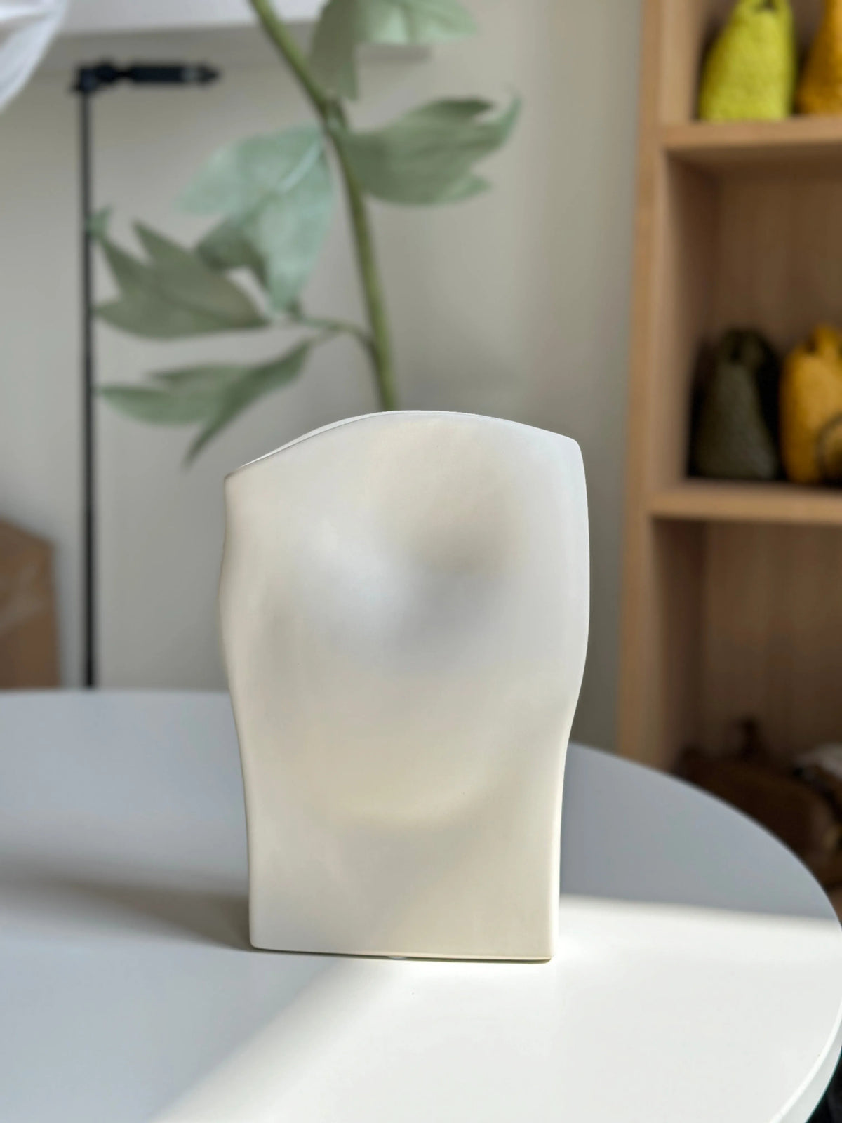 Wave ceramic vase in cream styled on a table with greenery, draped sculptural silhouette