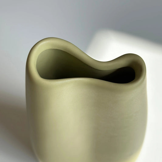Bifold ceramic vase in yellow, top view of the wavy folded rim and pinched opening